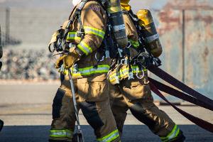 Firefighters holding firehoses