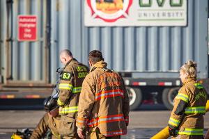 Firefighters holding firehoses