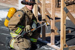 Firefighter using a crowbar on a wooden structure