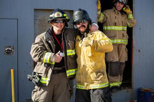 Two firefighters taking a picture together with both doing a thumbs up