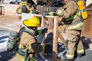 Firefighters using a crowbar on a wooden structure