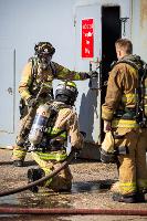 Firefighters looking into a metal door