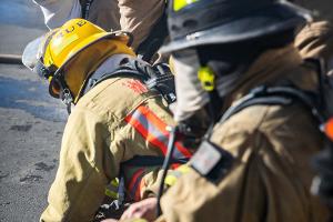 Four firefighters gearing up with equipment