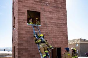 Firefighter training to rescuing another firefighter on a ladder