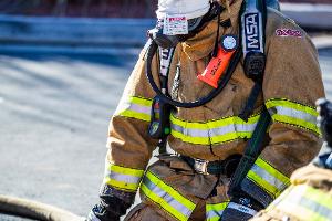 Firefighter using breathing apparatus, treating a training dummy