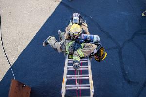 Firefighter training to rescuing another firefighter on a ladder