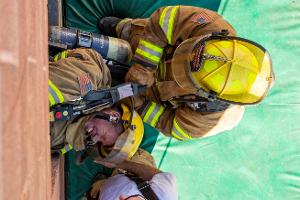 Firefighter training to rescuing another firefighter on a ladder