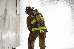 Firefighter spraying firehose