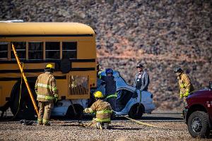 Firefighters run a hose to a bus