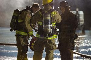 Firefighters walking into smoky building