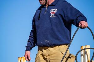 A firefighting instructor supervising holding a hose