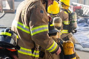 Four firefighters gearing up with equipment