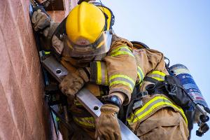 Firefighter training to rescuing another firefighter on a ladder