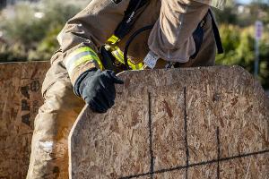 Firefighter holding a piece of plywood.