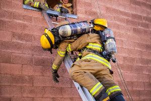 Firefighter training to rescuing another firefighter on a ladder