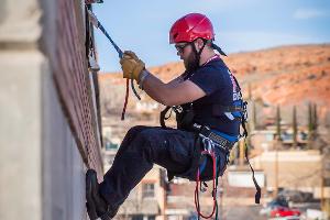 Man repelling down a building