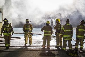 Firefighters walking into smoky building