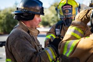 Supervising firefighter talking with two firefighters