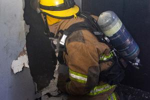 Firefighter breaking through a wall