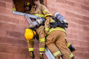 Firefighter training to rescuing another firefighter on a ladder