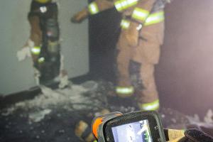 Firefighter breaking through a wall