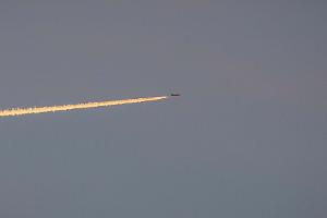 Airplane flying in the sky with a trail behind it