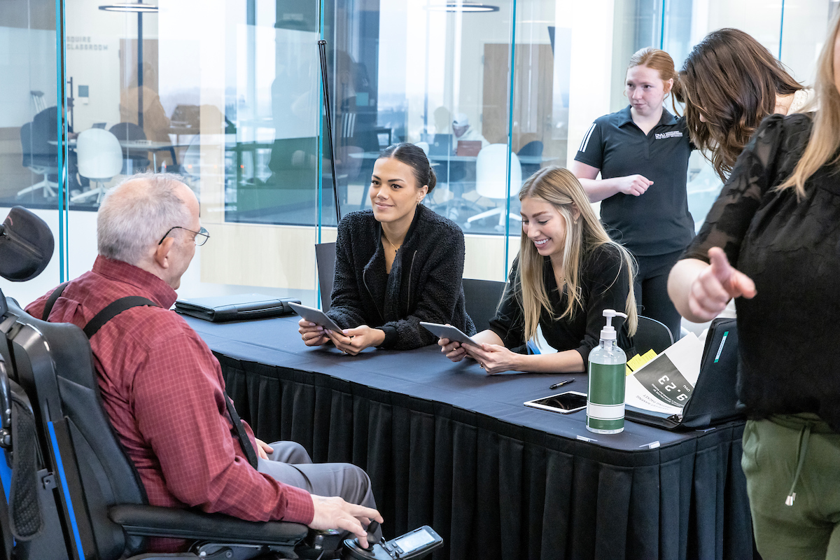 Event ambassadors help people check into an event