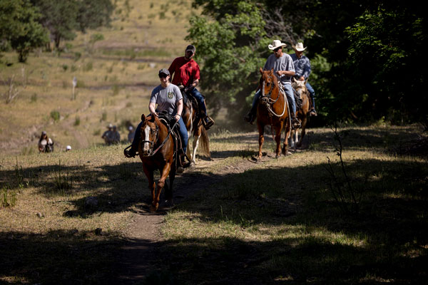Veterans riding horses as part of the UVU VA work study program
