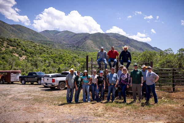 Veterans posed on a fence near horse trailers as part of the UVU VA work study program