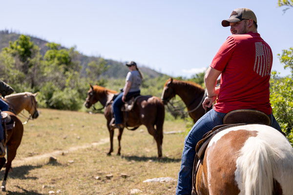 Veterans riding horses in the UVU work study program