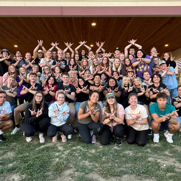 UVU Ambassadors doing the UVU hand sign