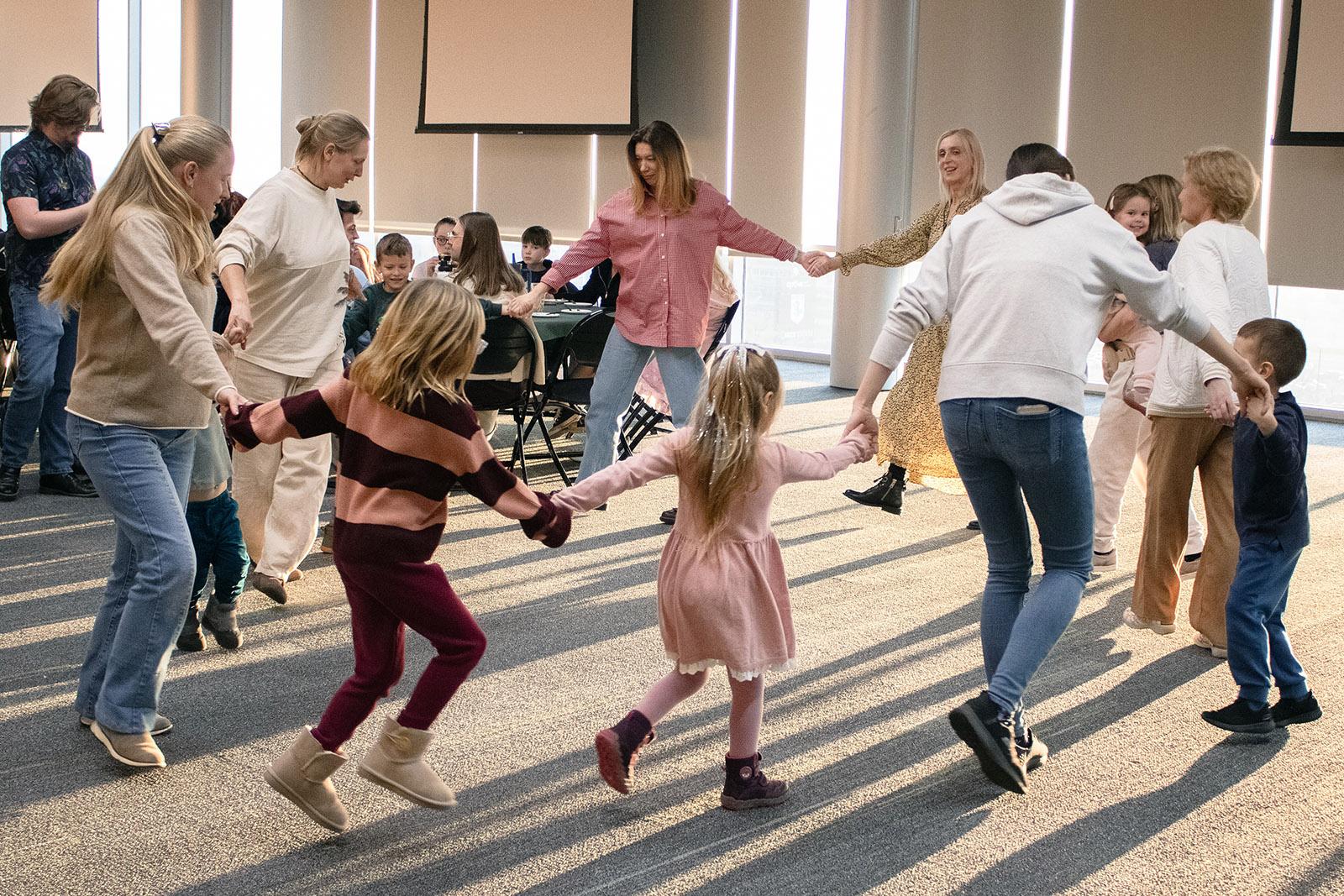 A group of people holding hands in a circle and dancing