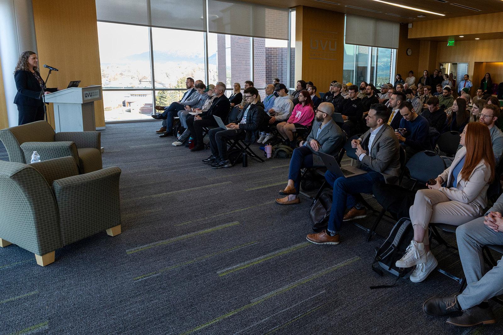 Full room of audience and speaker Sonata Coulter