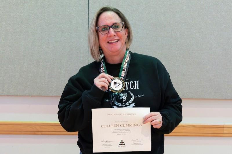 Counselor poses with award
