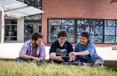 Students sitting in the grass at the library.