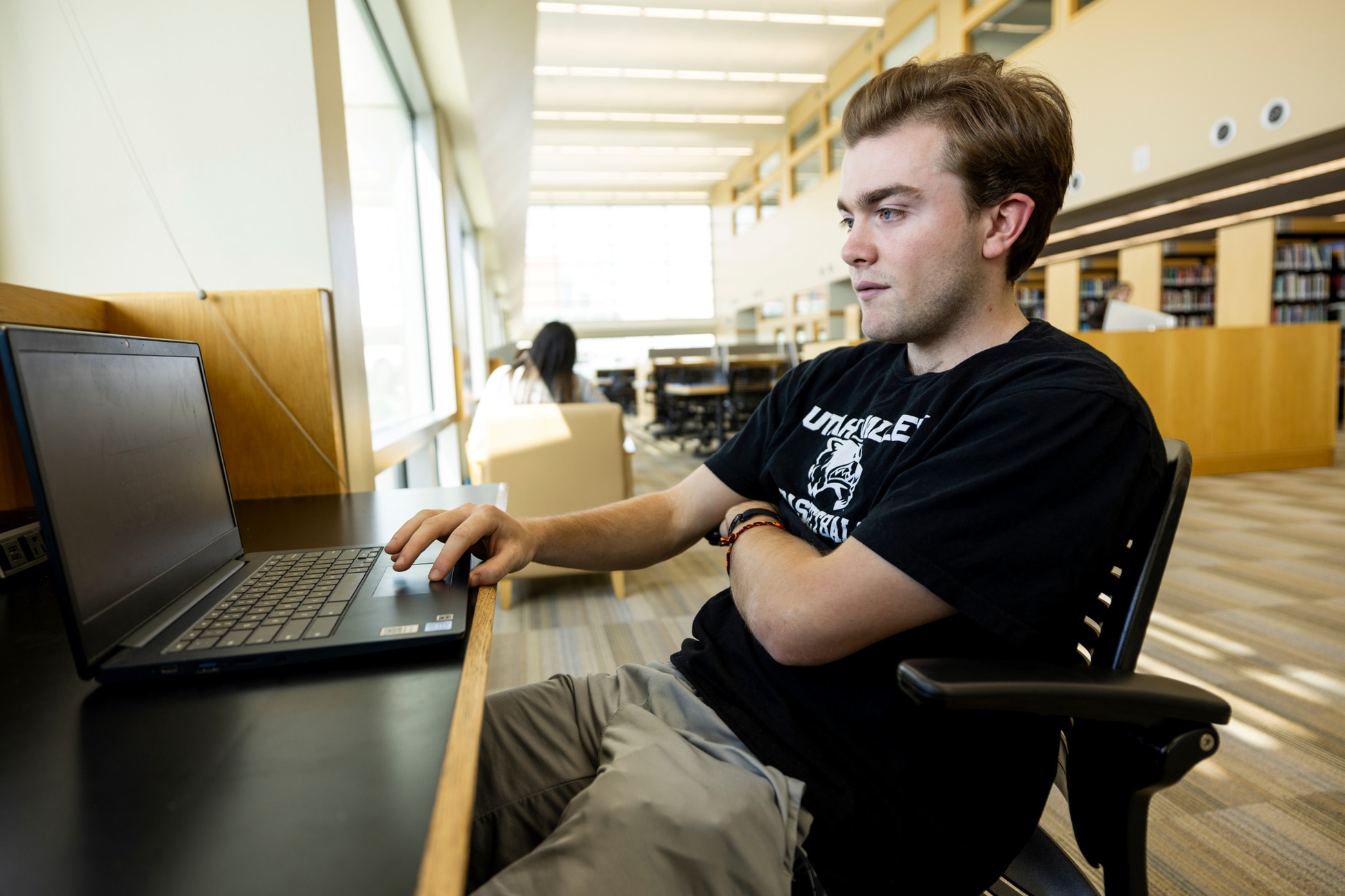 Man studying on a laptop in the library.