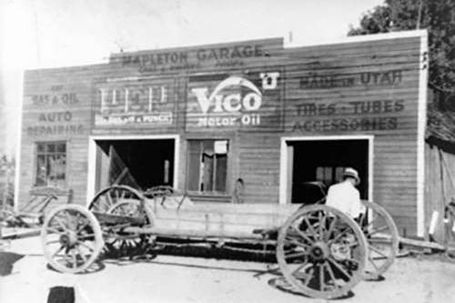Black and white image of a wooden store front with a wagon out front.