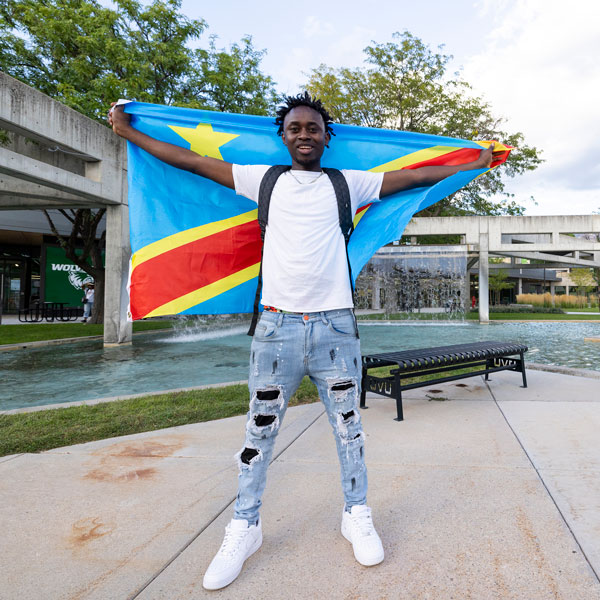 A black UVU student posing with the flag of the Democratic Republic of Congo