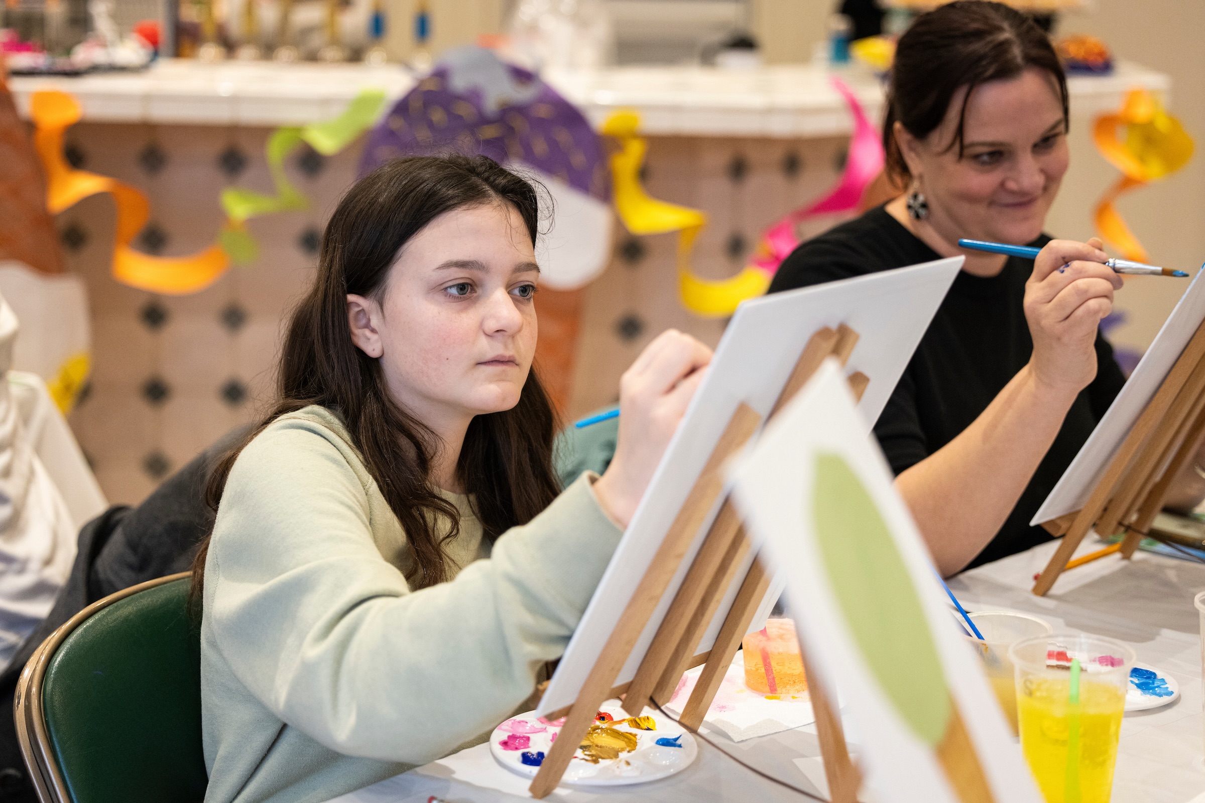 Image of a girl painting on a canvas in the UVU Museum Art Haus- decorative image