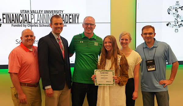 A team of high school students pose with their financial planning certificate. 