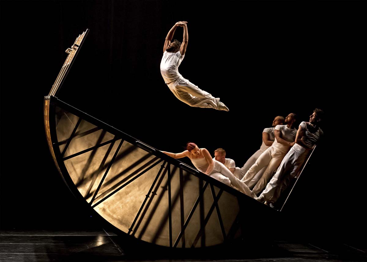 Diavolo trajectorie. A dancer poses midair over a prop ship.
