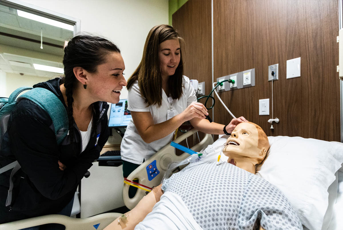 Nursing students demonstrate patient mannequins at the Nursing Student Learning and Simulation Center