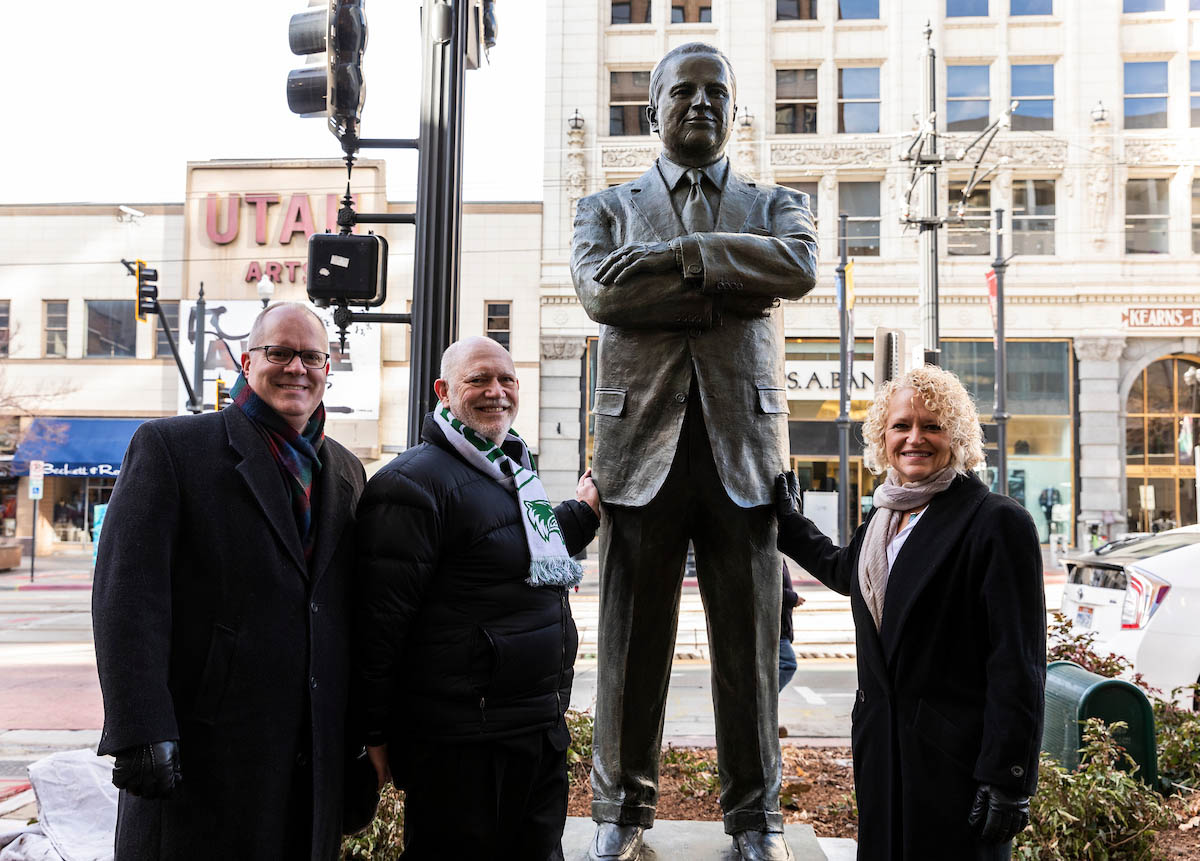 Daniel Fairbanks and Mayor Jackie Biskupski pose with sculpture of Vasilios Priskos.