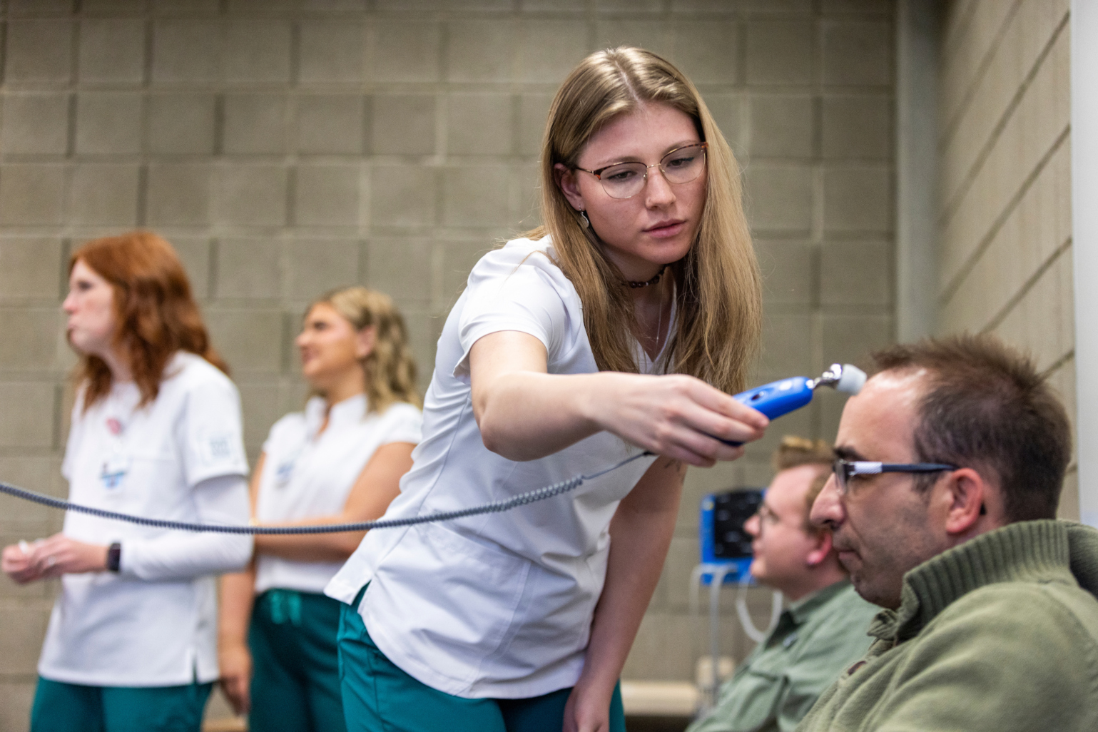 a nurse takes the temperature of a patient