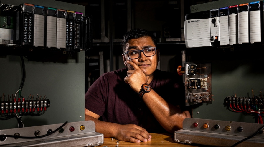 Student seated at a desk with equipment.