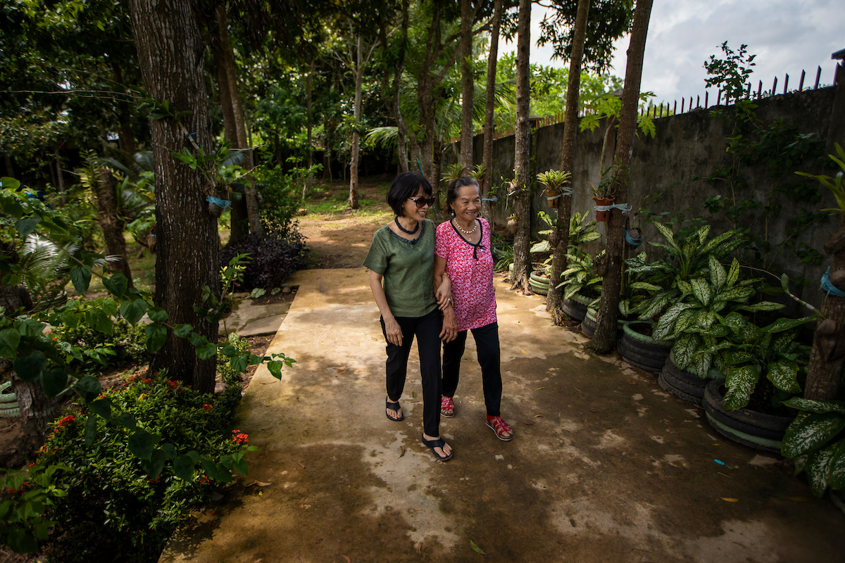 President Tuminez walks with her mother in the Philippines.