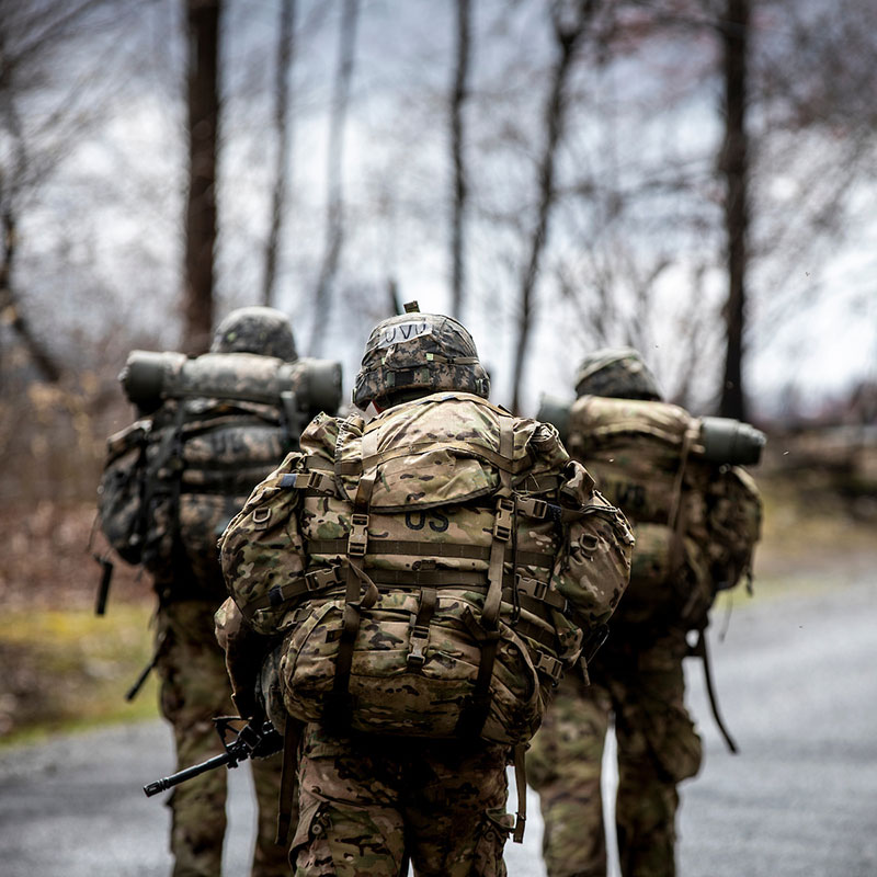 Three rangers walking away with backpacks on