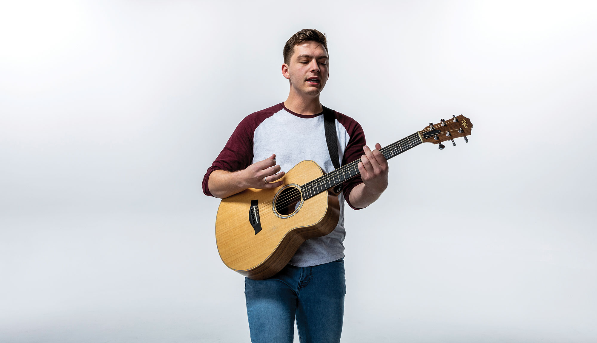 Charlie playing guitar with white backdrop