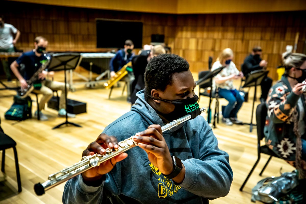 UVU student Desmond Walker plays the flute through a unique mask to maintain safety during Wind Symphony practice.