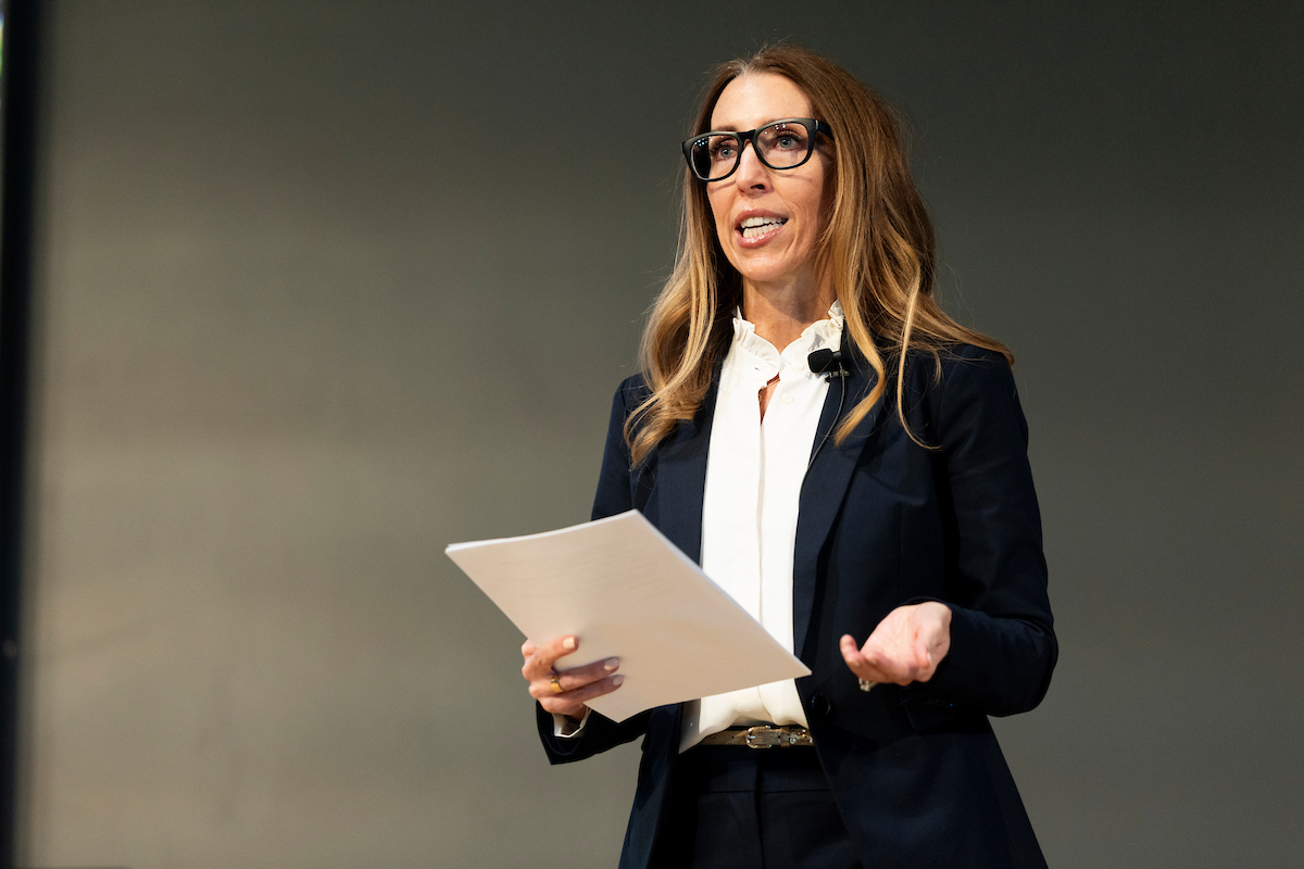 Nanette Graviet speaking to lecture attendees on stage at the Halladay Lecture Series. 